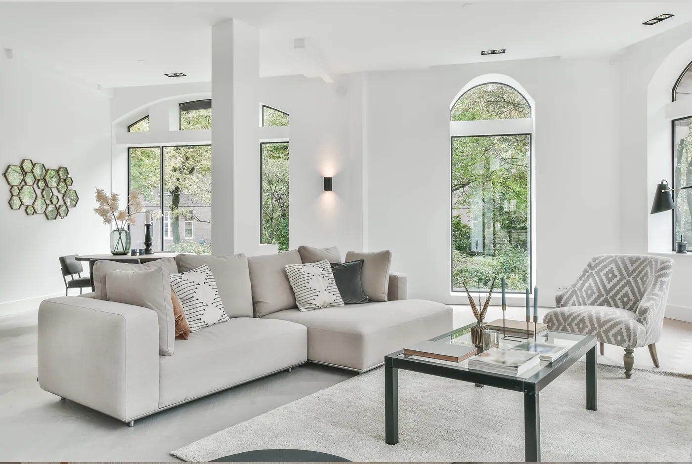 Bright staged living room with tall arched windows photographed for a real estate listing