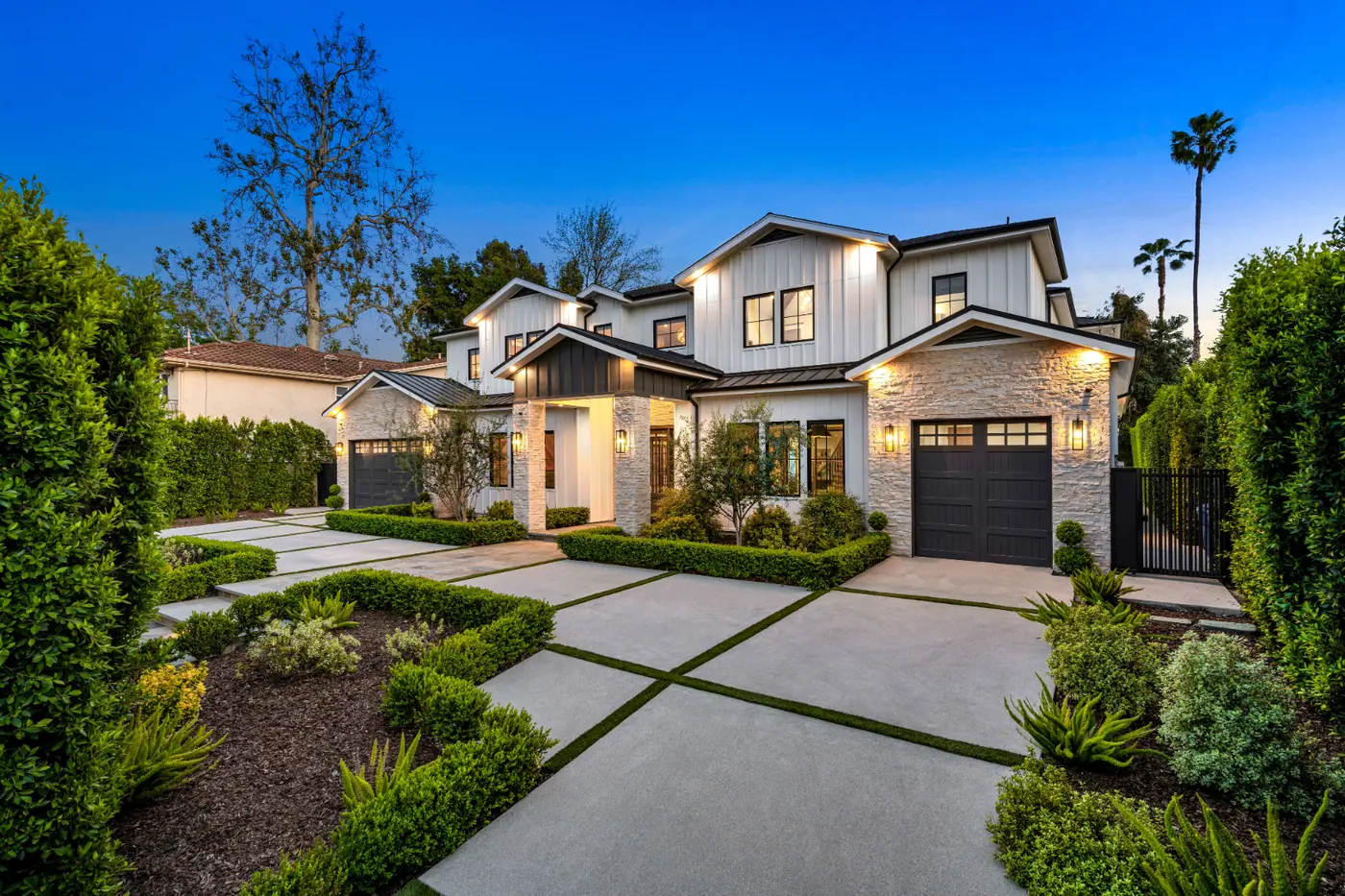 Two-story home photographed at twilight with exterior lights on
